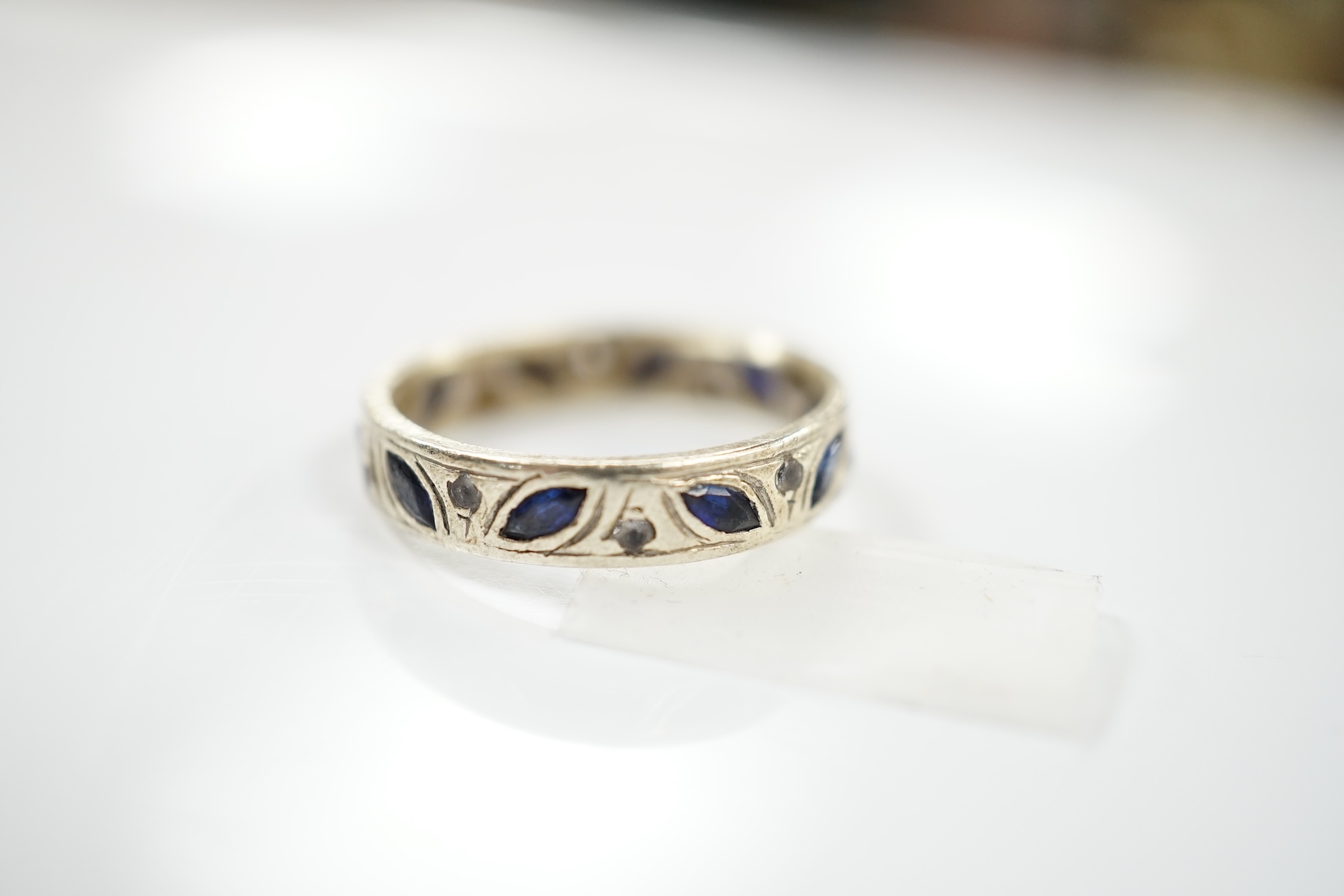 A 9ct white metal, shaped sapphire and diamond chip set eternity ring, size N, gross weight 3.7 grams. Condition - poor